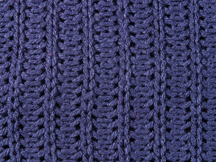 Detailed view of a blue knitted wool fabric with intricate weave pattern.