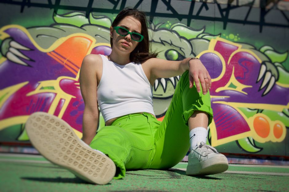 Street fashion photo featuring a woman in vibrant pants against a graffiti wall.