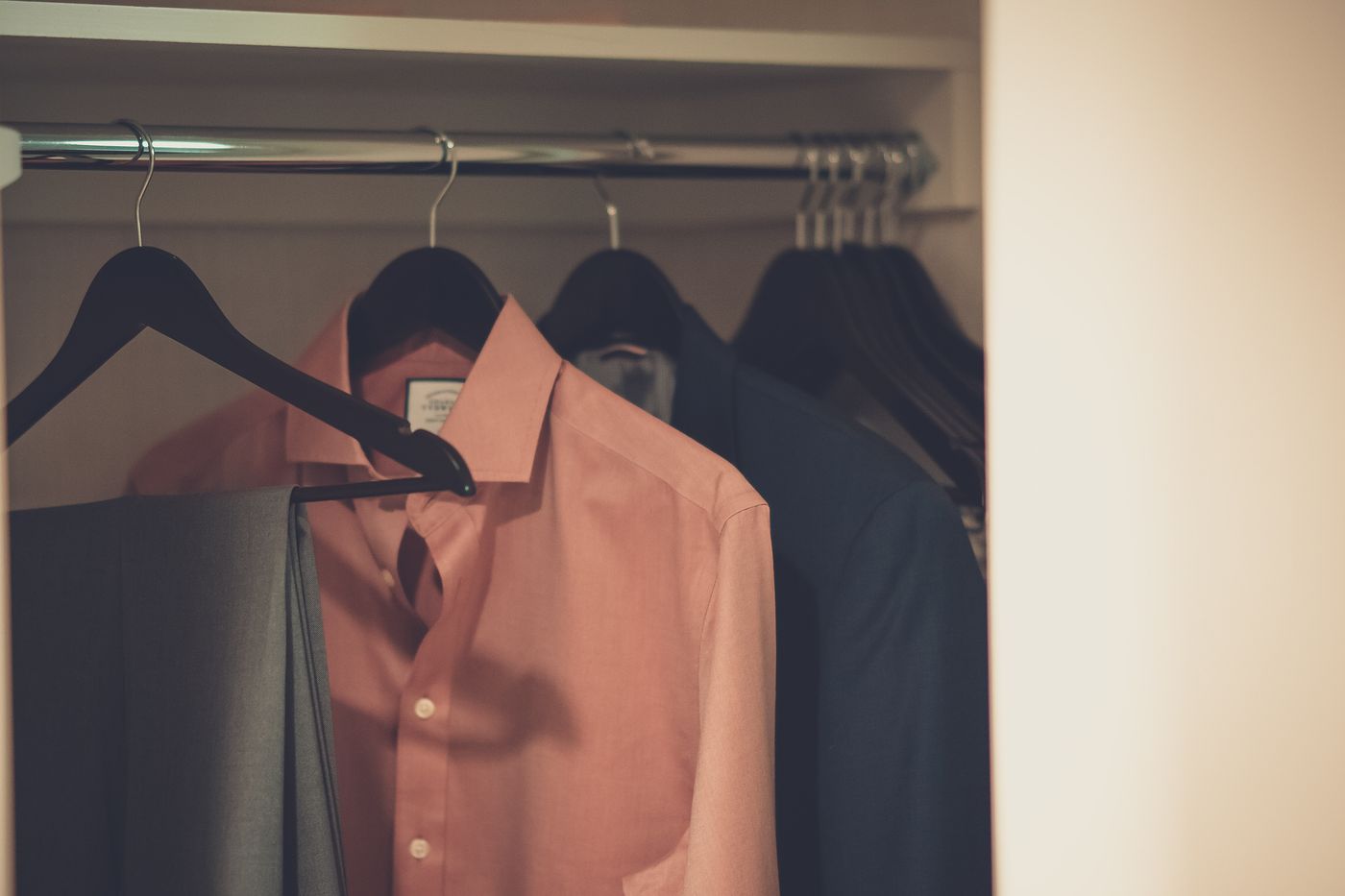 Mens shirts and jackets arranged neatly in a wardrobe