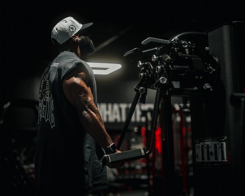 An adult man intensely exercising with gym equipment, showcasing strength and determination.