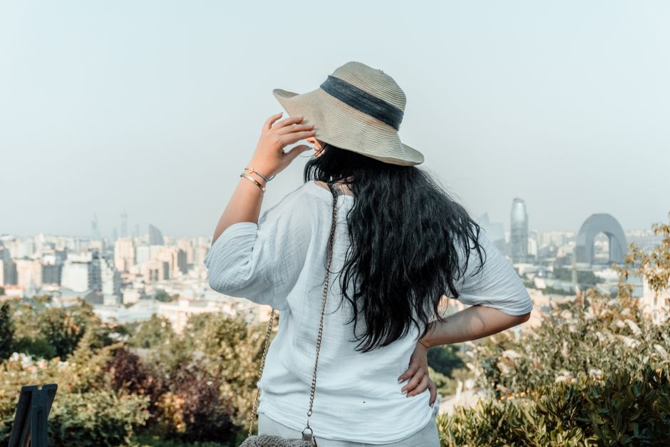 Woman in a sunhat admiring the Baku cityscape, Azerbaijan in the daytime.