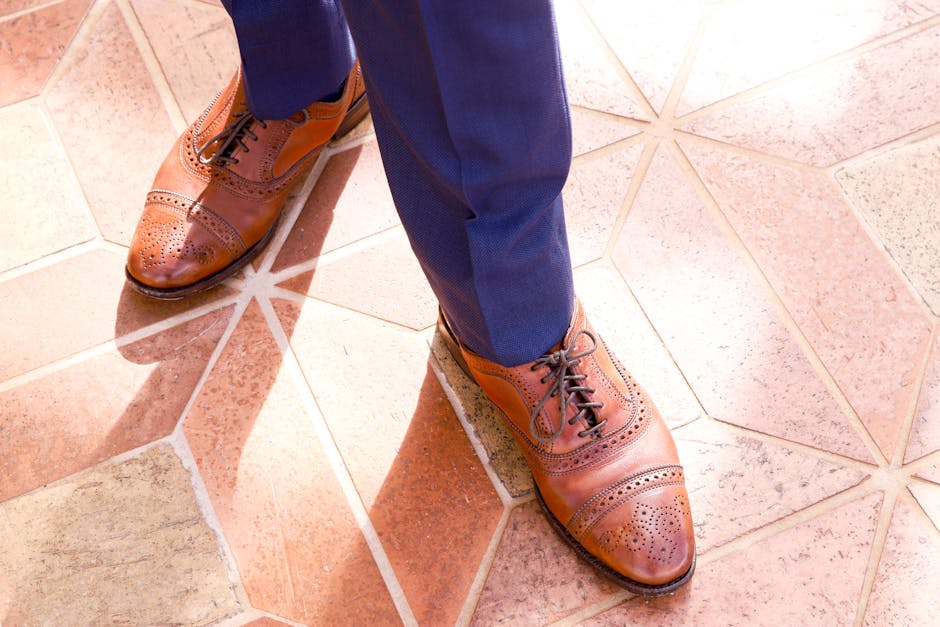 Stylish brown brogue shoes paired with a blue suit, perfect for formal or wedding occasions.