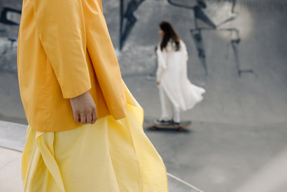 Stylish women in vibrant clothing skateboarding in an artistic urban skatepark setting.